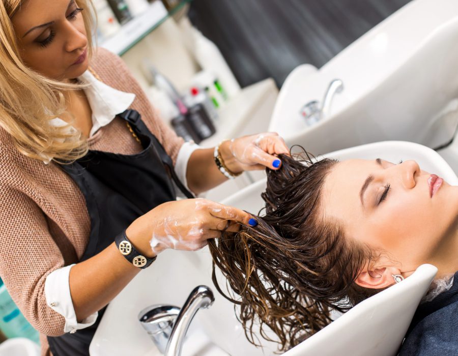 Hairdresser salon. Woman during hair wash